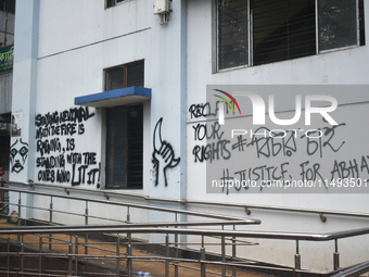 A woman is passing next to a mural with slogans inside Kolkata Medical College and Hospital campus condemning the rape and murder of a train...