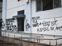 A woman is passing next to a mural with slogans inside Kolkata Medical College and Hospital campus condemning the rape and murder of a train...