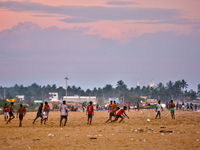 Youth are playing a game of football (soccer) by the ocean at sunset along Paruthiyoor Beach in Paruthiyoor, Kerala, India, on April 15, 202...