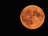 A rare super blue full moon appears rising in the night sky over tall buildings, near the city of Eindhoven in the Netherlands on August 19,...