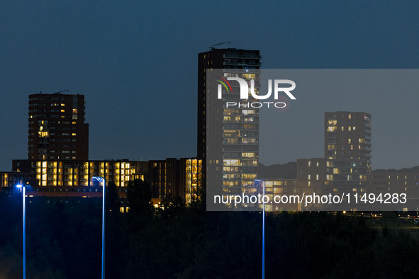 A rare super blue full moon appears rising in the night sky over tall buildings, near the city of Eindhoven in the Netherlands on August 19,...