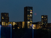 A rare super blue full moon appears rising in the night sky over tall buildings, near the city of Eindhoven in the Netherlands on August 19,...