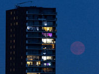 A rare super blue full moon appears rising in the night sky over tall buildings, near the city of Eindhoven in the Netherlands on August 19,...