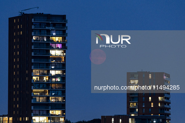 A rare super blue full moon appears rising in the night sky over tall buildings, near the city of Eindhoven in the Netherlands on August 19,...