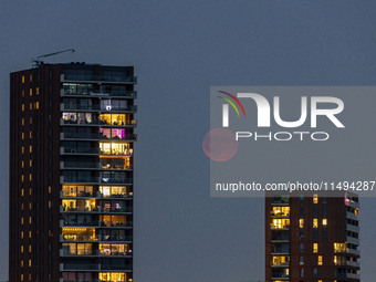 A rare super blue full moon appears rising in the night sky over tall buildings, near the city of Eindhoven in the Netherlands on August 19,...