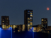 A rare super blue full moon appears rising in the night sky over tall buildings, near the city of Eindhoven in the Netherlands on August 19,...