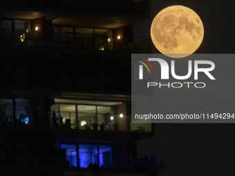 A rare super blue full moon appears rising in the night sky over tall buildings, near the city of Eindhoven in the Netherlands on August 19,...