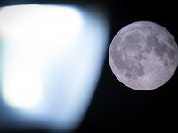 A rare super blue full moon appears rising in the night sky over tall buildings, near the city of Eindhoven in the Netherlands on August 19,...