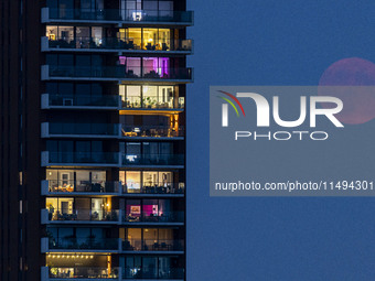 A rare super blue full moon appears rising in the night sky over tall buildings, near the city of Eindhoven in the Netherlands on August 19,...