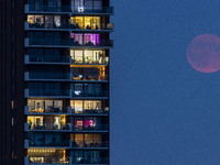 A rare super blue full moon appears rising in the night sky over tall buildings, near the city of Eindhoven in the Netherlands on August 19,...