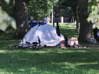 A homeless man is setting up a tent in Queens Park in downtown Toronto, Ontario, Canada, on August 14, 2024. Homelessness is plaguing the ci...