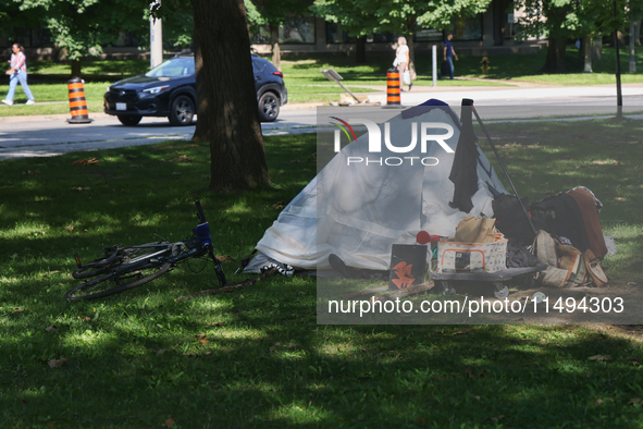 A homeless man is setting up a tent in Queens Park in downtown Toronto, Ontario, Canada, on August 14, 2024. Homelessness is plaguing the ci...