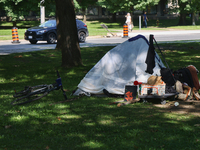 A homeless man is setting up a tent in Queens Park in downtown Toronto, Ontario, Canada, on August 14, 2024. Homelessness is plaguing the ci...