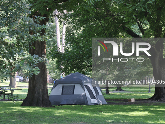 A homeless man is setting up a tent in Queens Park in downtown Toronto, Ontario, Canada, on August 14, 2024. Homelessness is plaguing the ci...