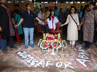 Medical students and doctors are making a human chain with a clay model of a female doctor, a replica of a victim of rape and murder, at R G...