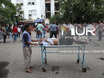 A patient is on a trolley while medical students and doctors are making a human chain during a protest at National Medical College & Hospita...