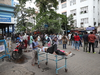 A patient is on a trolley while medical students and doctors are making a human chain during a protest at National Medical College & Hospita...