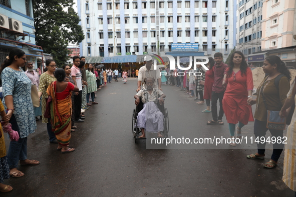 Medical students and doctors are making a human chain during a protest against the rape and murder of a PGT woman doctor at Government-run R...