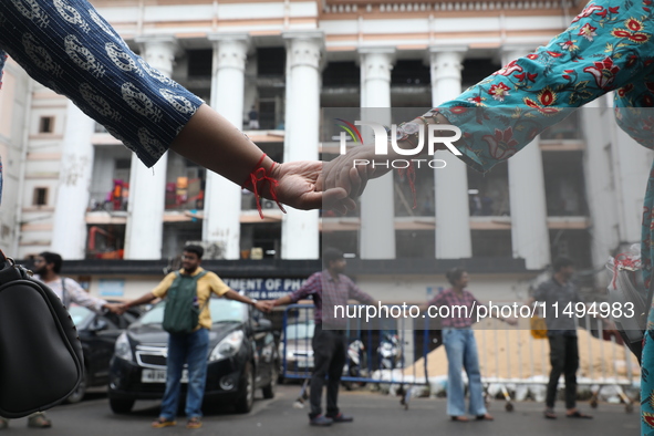 Medical students and doctors are making a human chain during a protest at National Medical College & Hospital against the rape and murder of...