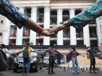 Medical students and doctors are making a human chain during a protest at National Medical College & Hospital against the rape and murder of...