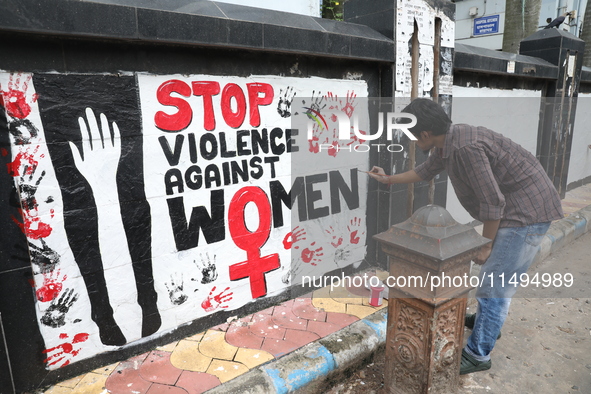 A junior doctor is painting slogans inside National Medical College & Hospital in Kolkata, India, on August 19, 2024, as a protest against t...