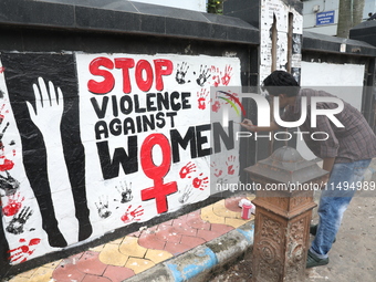 A junior doctor is painting slogans inside National Medical College & Hospital in Kolkata, India, on August 19, 2024, as a protest against t...