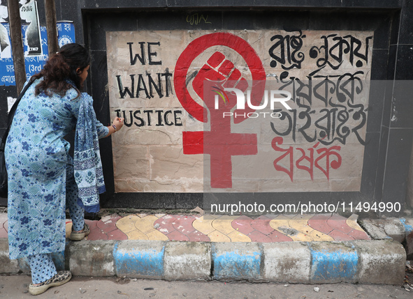 A junior doctor is painting slogans inside National Medical College & Hospital in Kolkata, India, on August 19, 2024, as a protest against t...