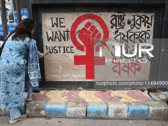 A junior doctor is painting slogans inside National Medical College & Hospital in Kolkata, India, on August 19, 2024, as a protest against t...