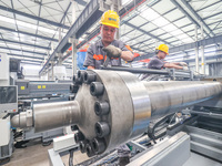 A worker is producing injection molding machines for export at a workshop in Huzhou, Zhejiang province, China, on August 20, 2024. (