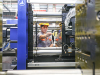 A worker is producing injection molding machines for export at a workshop in Huzhou, Zhejiang province, China, on August 20, 2024. (