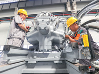 Workers are producing injection molding machines for export at a workshop in Huzhou, Zhejiang province, China, on August 20, 2024. (