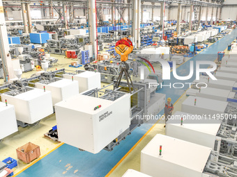 Workers are producing injection molding machines for export at a workshop in Huzhou, Zhejiang province, China, on August 20, 2024. (