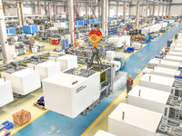 Workers are producing injection molding machines for export at a workshop in Huzhou, Zhejiang province, China, on August 20, 2024. (