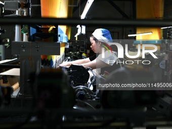 A female textile worker is working at a jacquard loom workshop at Jiangsu Hengyuan Silk Group located in the high-tech zone in Hai 'an, Jian...