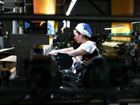 A female textile worker is working at a jacquard loom workshop at Jiangsu Hengyuan Silk Group located in the high-tech zone in Hai 'an, Jian...