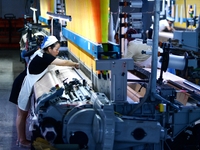 A female textile worker is working at a jacquard loom workshop at Jiangsu Hengyuan Silk Group located in the high-tech zone in Hai 'an, Jian...