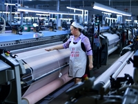 A female textile worker is working at a jacquard loom workshop at Jiangsu Hengyuan Silk Group located in the high-tech zone in Hai 'an, Jian...