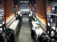 A female textile worker is working at a jacquard loom workshop at Jiangsu Hengyuan Silk Group located in the high-tech zone in Hai 'an, Jian...