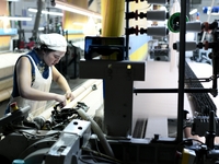 A female textile worker is working at a jacquard loom workshop at Jiangsu Hengyuan Silk Group located in the high-tech zone in Hai 'an, Jian...