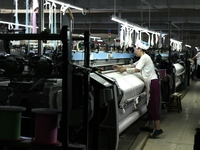 A female textile worker is working at a jacquard loom workshop at Jiangsu Hengyuan Silk Group located in the high-tech zone in Hai 'an, Jian...