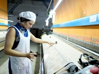 A female textile worker is working at a jacquard loom workshop at Jiangsu Hengyuan Silk Group located in the high-tech zone in Hai 'an, Jian...