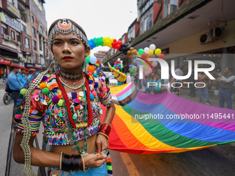 A member of the sexual minority LGBTIQ+ group of Nepal is holding the edge of a rainbow flag during the Gaijatra (Pride) parade in Kathmandu...