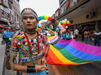 A member of the sexual minority LGBTIQ+ group of Nepal is holding the edge of a rainbow flag during the Gaijatra (Pride) parade in Kathmandu...