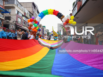 Members of the sexual minority LGBTIQ+ group of Nepal are unfurling the rainbow flag, holding its edges before the formal start of the Gaija...