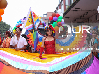 A member of the sexual minority LGBTIQ+ group of Nepal is holding the edge of a rainbow flag during the Gaijatra (Pride) parade in Kathmandu...