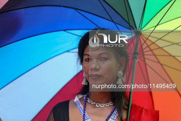 A member of the sexual minority LGBTIQ+ group of Nepal is wearing a rainbow-colored umbrella during the Gaijatra (Pride) parade in Kathmandu...