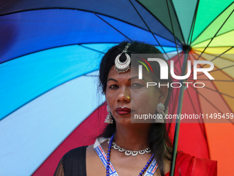 A member of the sexual minority LGBTIQ+ group of Nepal is wearing a rainbow-colored umbrella during the Gaijatra (Pride) parade in Kathmandu...