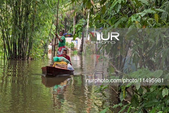 Bangladeshi people suffer from floods during heavy monsoon rains in rural Bangladesh on August 20, 2024. 