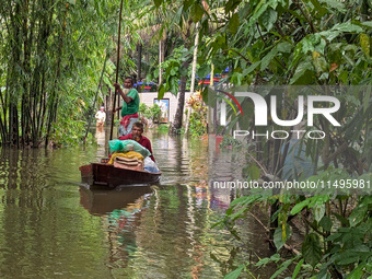 Bangladeshi people suffer from floods during heavy monsoon rains in rural Bangladesh on August 20, 2024. (