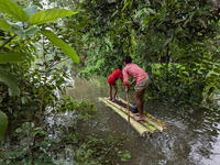 Bangladeshi people suffer from floods during heavy monsoon rains in rural Bangladesh on August 20, 2024. (